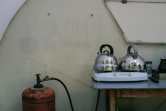 Camping setup with kettles and stove near eco-friendly glamping site