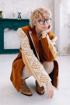 Woman squatting in a room wearing a brown Fashion blazer