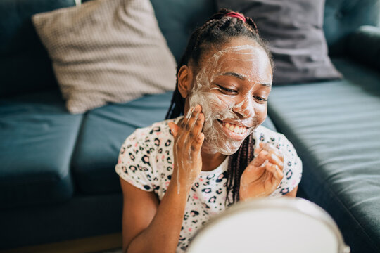 Home portrait of happy african american woman doing skincare with foam