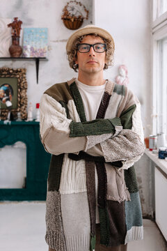 Young man poses with arms crossed in a stylish sweater