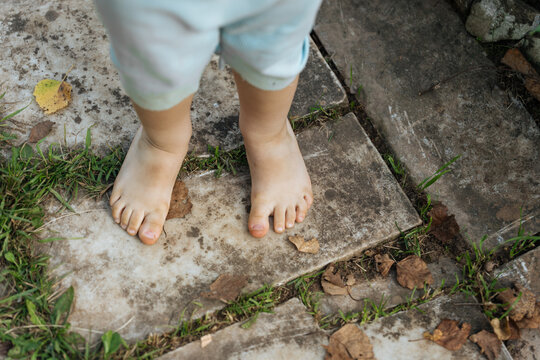  Barefoot child standing on stone path