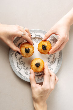 Puff pastry bites topped with black caviar on decorative plate