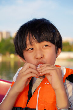 Closeup of a Chinese boy sucking on a sweet treat

