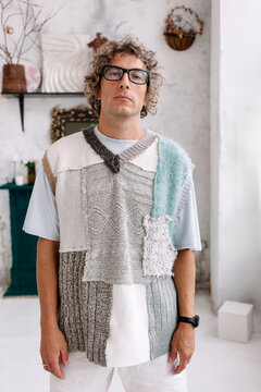 A man wearing unique patchwork sweater in modern indoor space 
