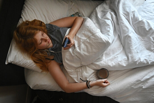 A teenage girl lies in bed 