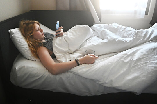 A teenage girl lies in bed 