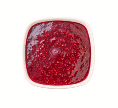 white ceramic bowl of raspberry jam isolated on white background, top view.