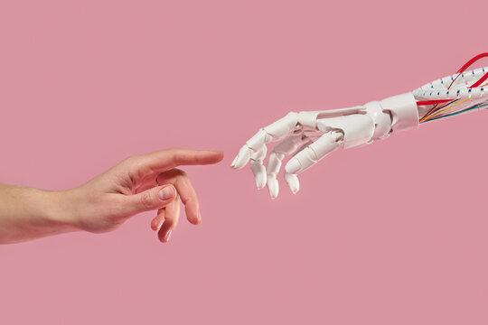 Human and robot touch on pink background