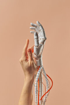 Human hand touch robotic arm on beige background
