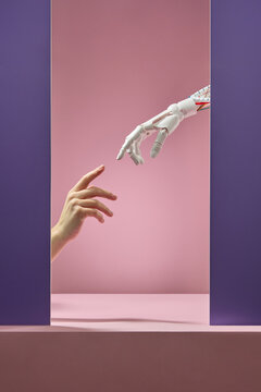 Human hand reaches robot hand through doorway