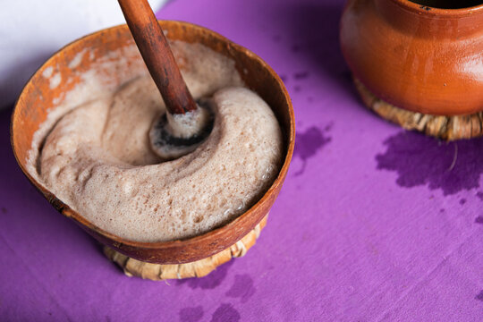 Traditional Beverage Preparation in Earthy Bowl