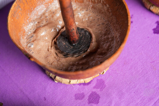 Bubbling chocolate drink mixture in a clay bowl