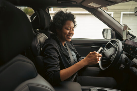 Woman using phone in car interior
