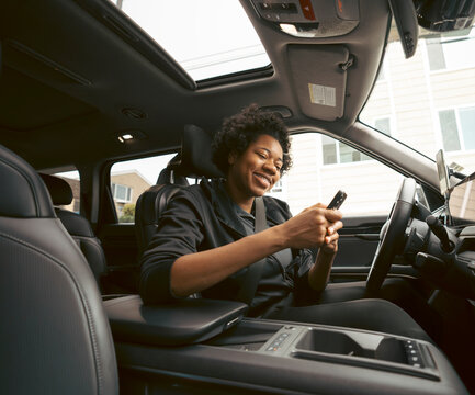 Woman using phone in car interior
