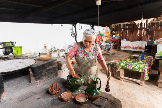 Woman preparing ingredients in a traditional rustic kitchen