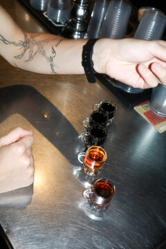 Anonymous person buying shots at bar counter