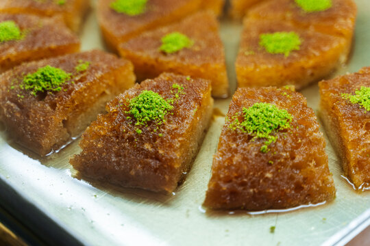 Syrupy semolina dessert topped with pistachio