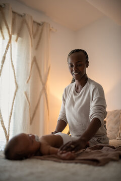Excited mother stretching her newborn baby back