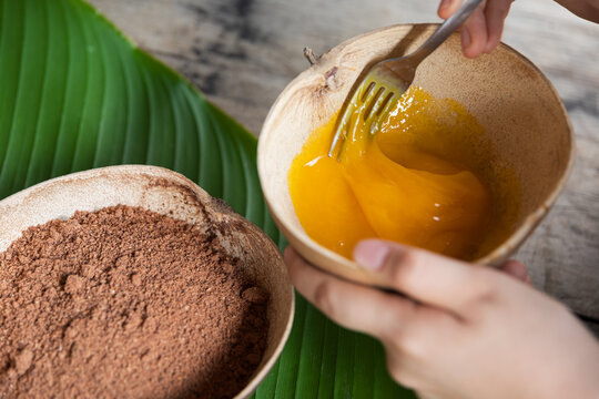 Mixing fresh eggs with cacao powder ingredients