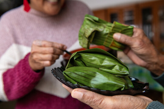 Traditional Indonesian rice parcels in banana leaves held by hands