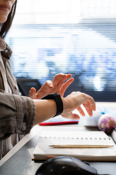 Person Checks Smartwatch in a Workspace During the Day