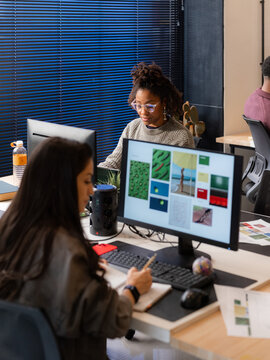 Candid women working at office on creative project 