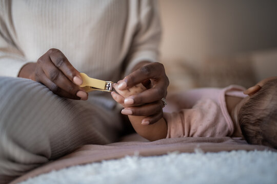 Parent Cuts Nails of Baby in Quiet Room During Daytime Hours