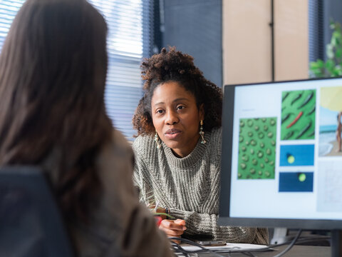 Woman Talks With Colleague in an Office During the Day