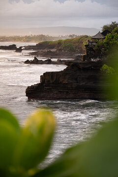 Rocky cliffs and tropical coastline at sunset in Bali.