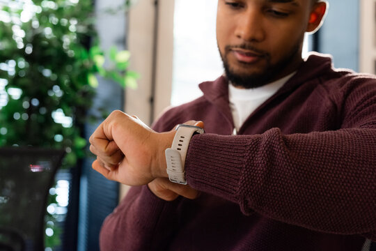 Man Checks Smartwatch while Working 