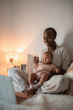 Woman having video call with baby on laps 