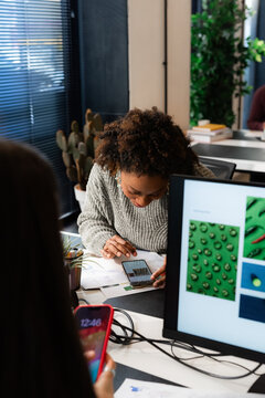 Women using their smartphones at office desk 