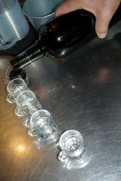 Bartender Pours Liquor Into Shot Glasses 