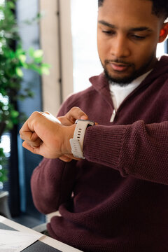 Man checking his smartwatch at workplace 