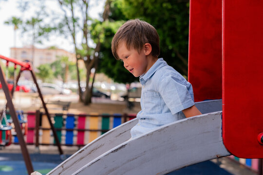 Boy enjoying sliding at playground 