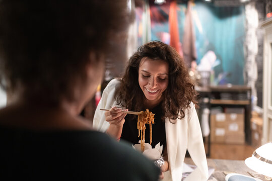 Happy businesswoman having lunch with coworker