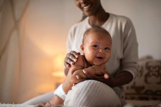 Cheerful baby enjoying massage from mother 