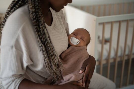Mother holding and lulling baby at home 