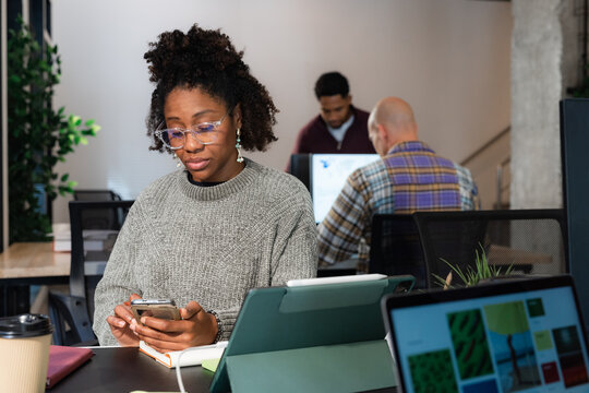Woman using smartphone at her desk 