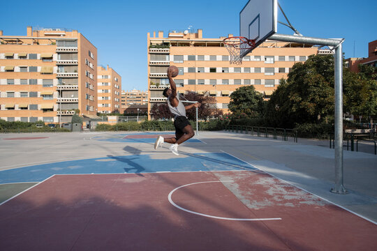 Black man scoring ball during basketball match