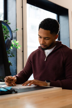 Focused worker making notes in document at work 