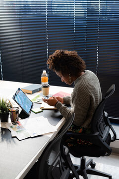 Woman texting message on her smartphone at work 