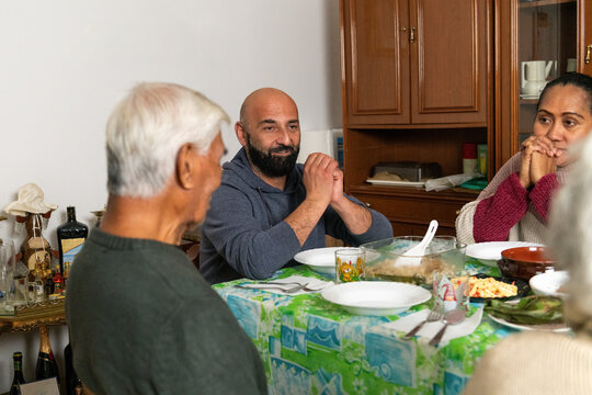 Family praying together before sharing an Indonesian meal