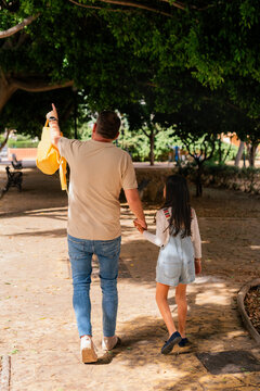 Father walking with daughter in park