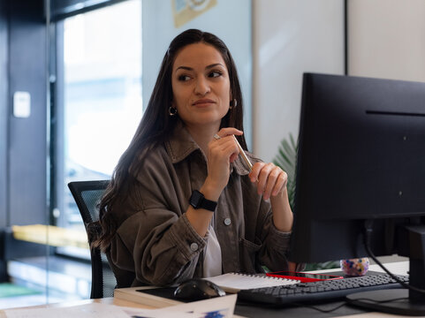 Woman looking away while sitting at her desk 