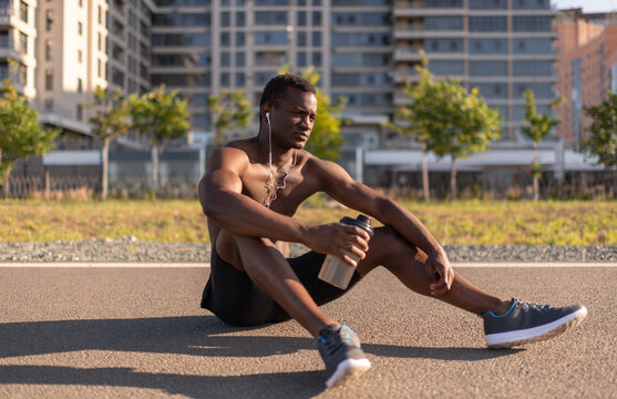 Sportsman sitting on racetrack with water bottle
