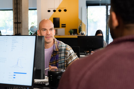 Man listening to colleague at work attentively 