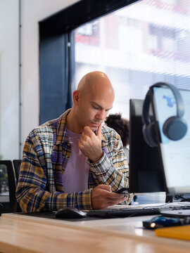 Man reading text message on smartphone at work 