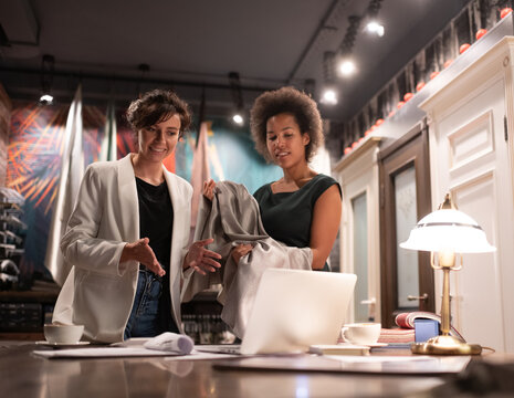 Diverse female designers showing cloth to online client
