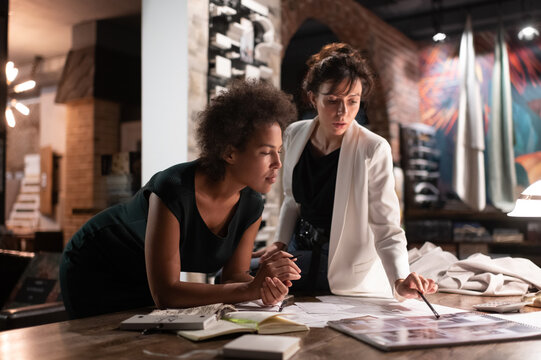 Diverse female architects discussing project in office